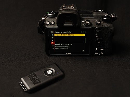 Gii Pro beside a Nikon camera showing a connected device and the location data menu